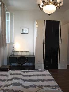 a bedroom with a bed and a desk and a chandelier at Vishapaqagh in Yerevan +12 photos