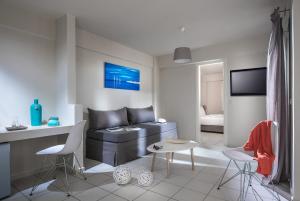 a living room with a couch and a table and chairs at Bianca Doma Adults Only by Estia in Hersonissos