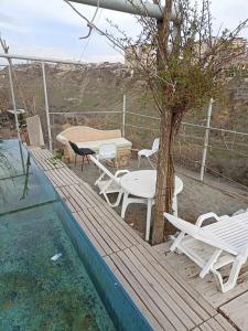 a wooden deck with a table and chairs next to a tree at Vishapaqagh in Yerevan