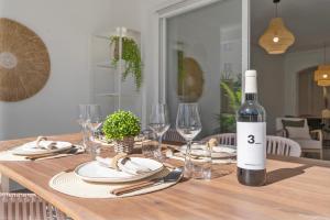 a wooden table with a bottle of wine and glasses at Medina Garden 201 in Marbella