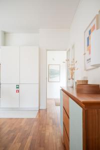 a kitchen with white cabinets and a wooden floor at Bombarda Homes in Porto