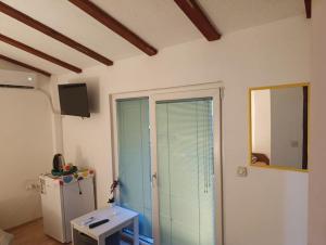 a room with a refrigerator and a sliding glass door at Rooftop rooms Ohrid in Ohrid