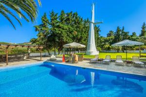 a swimming pool with a cross in the background at Albero Villa Polychrono in Polychrono