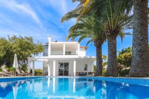 a villa with a swimming pool and palm trees at Albero Villa Polychrono in Polychrono