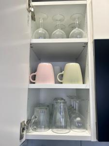 une armoire remplie de vaisselle et de bocaux en verre dans l'établissement Studio devant la gare Saint-Charles, à Marseille