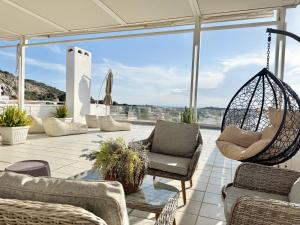 a patio with chairs and a swing at Villasonboard 3 Bed Penthouse Veranda Beach view jacuzzi Vouliagmeni Riviera in Athens
