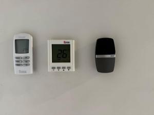 a clock and an electronic device sitting on a table at Warm and romantic cottage-4Bed-9guests in Tarneit