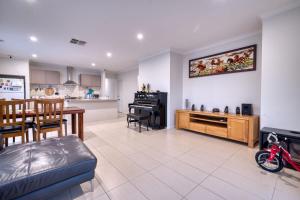 a large living room with a table and a kitchen at Warm and romantic cottage-4Bed-9guests in Tarneit