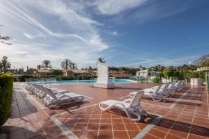 Una fila de tumbonas junto a una piscina. en Private Solarium Bungalow Garden, en Maspalomas