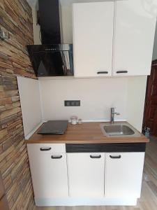 a kitchen with a sink and a laptop on a counter at Mi rincón de Candeleda in Candeleda