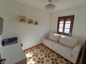 a living room with a white couch and a window at Mi rincón de Candeleda in Candeleda