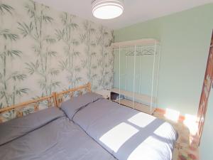 a bedroom with a bed and a green and white wallpaper at Mi rincón de Candeleda in Candeleda