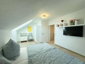 a bedroom with a bed and a flat screen tv at Wangermeer Perle II in Wangerland