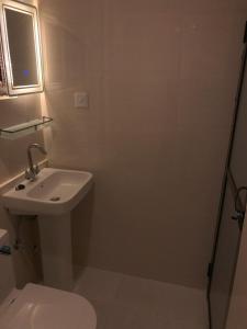 a white bathroom with a toilet and a sink at Zenith Apartments Thamel - Cho Oyu 1BHK Apartment in Kathmandu