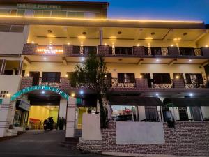 a large building with a sign in front of it at Cottage Club Inn in Almora