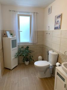 a bathroom with a toilet and a window at Hideaway Haven Villa in SantʼAnna Arresi
