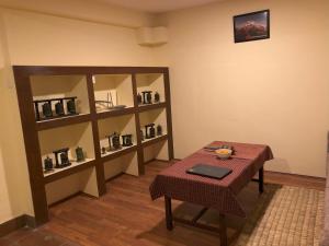 a room with a table and a shelf with glasses at Zenith Apartments Thamel - Manaslu 1BHK Apartment in Kathmandu