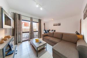 a living room with a couch and a table at Rio a Vista Praia da Rocha Flat in Portimão