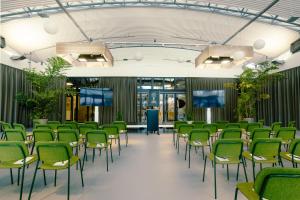a conference room with green chairs and tables at The Social Hub The Hague in The Hague