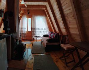 a living room with a couch and a window at M&K chalets in Žabljak
