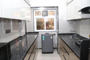 a kitchen with a sink and a refrigerator in it at UrbanNest Service Apartments Powai in Mumbai