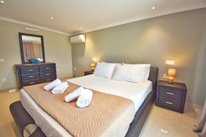 科孚镇Alykes Houses - Prv Jacuzzi的卧室里有一张床，床上放着两条毛巾。 更多63张照片