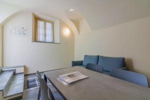 jadalnia ze stołem i niebieskimi krzesłami w obiekcie Tiny Duke Apartment w mieście Varenna
