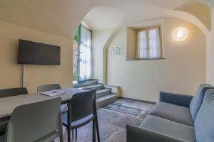 Pokój ze stołem i krzesłami oraz telewizorem w obiekcie Tiny Duke Apartment w mieście Varenna
