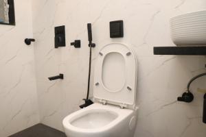 a bathroom with a toilet with the seat up at UrbanNest Service Apartments Powai in Mumbai