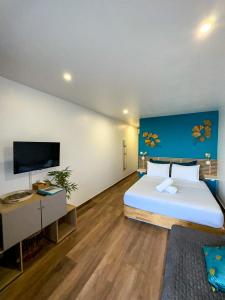a bedroom with a large bed and a flat screen tv at Studio vue mer avec piscine - Le Diamant in Le Diamant