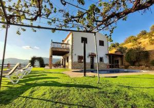 a house with a yard with a swing at Villa 10 by Villamya in El Gastor