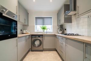 eine Küche mit Waschmaschine in der Unterkunft Ty Gwyrdd, 3 bedroom house, sleeps 7, Near Bike Park Wales in Abercanaid