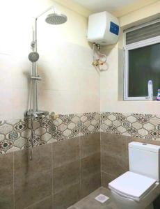 un bagno con doccia, WC e finestra di Spacious 3Bedroom Apartment in Muyenga, Bukasa Road a Kampala Altre 34 foto