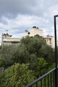 a view from a balcony of bushes and buildings at Niki's cozy apartment in Mytilene