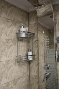 a bathroom with a shower with three shelves at Niki's cozy apartment in Mytilene +55 photos