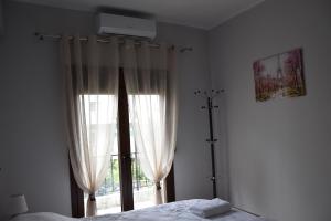 a bedroom with a bed and a large window at Niki's cozy apartment in Mytilene