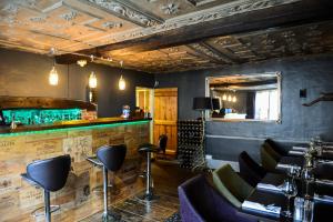 a bar with black chairs and a green counter at Sutherland House in Southwold