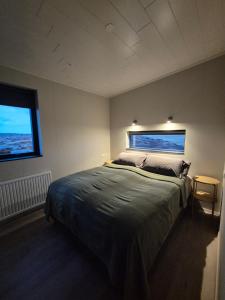 a bedroom with a large bed and a window at Bygghamar in Stykkishólmur