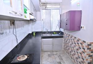 a small kitchen with a sink and a stove at Kashi Vishwanath Homestay in Varanasi