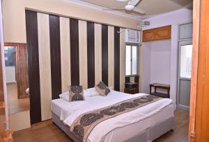 a bedroom with a bed with a striped wall at Kashi Vishwanath Homestay in Varanasi