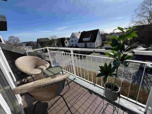 a balcony with two chairs and a view of a house at Ostsee-AuszeitDahme in Dahme