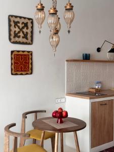 a kitchen with a table and chairs and lights at Nomad Soul in Almaty