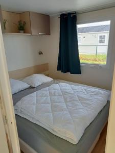 Rúm í herbergi á Stacaravan Bredene met tuin nr 2126
