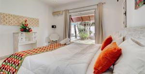 a bedroom with a large white bed with orange pillows at Oasis 1 Villa Tropicale in Grand Baie +32 photos