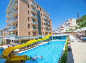 une piscine avec toboggan en face d'un bâtiment dans l'établissement Pool View Apartment - Diamond Hill Resort & SPA, à Vlorë