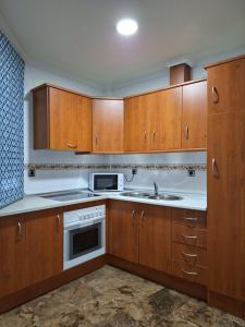a kitchen with wooden cabinets and a sink at Cazorla LIVE in Cazorla