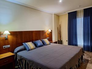 a bedroom with a large bed with blue and yellow pillows at Cazorla LIVE in Cazorla