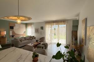 una sala de estar con un sofá y una mesa en Cosy flat - Garden - Swimming pool, en Valbonne 17 fotos más