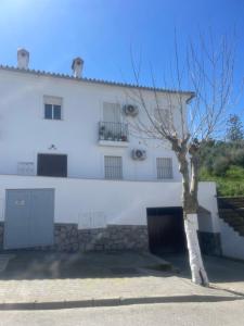 a white building with a tree in front of it at La Labranza del Bosque in El Bosque