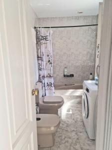 a white bathroom with a toilet and a sink at Casa rias baixas in Poio